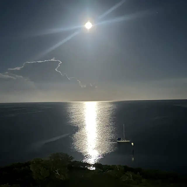Moonlight over the water in St. Petersburg, Florida, with a sailboat at anchor